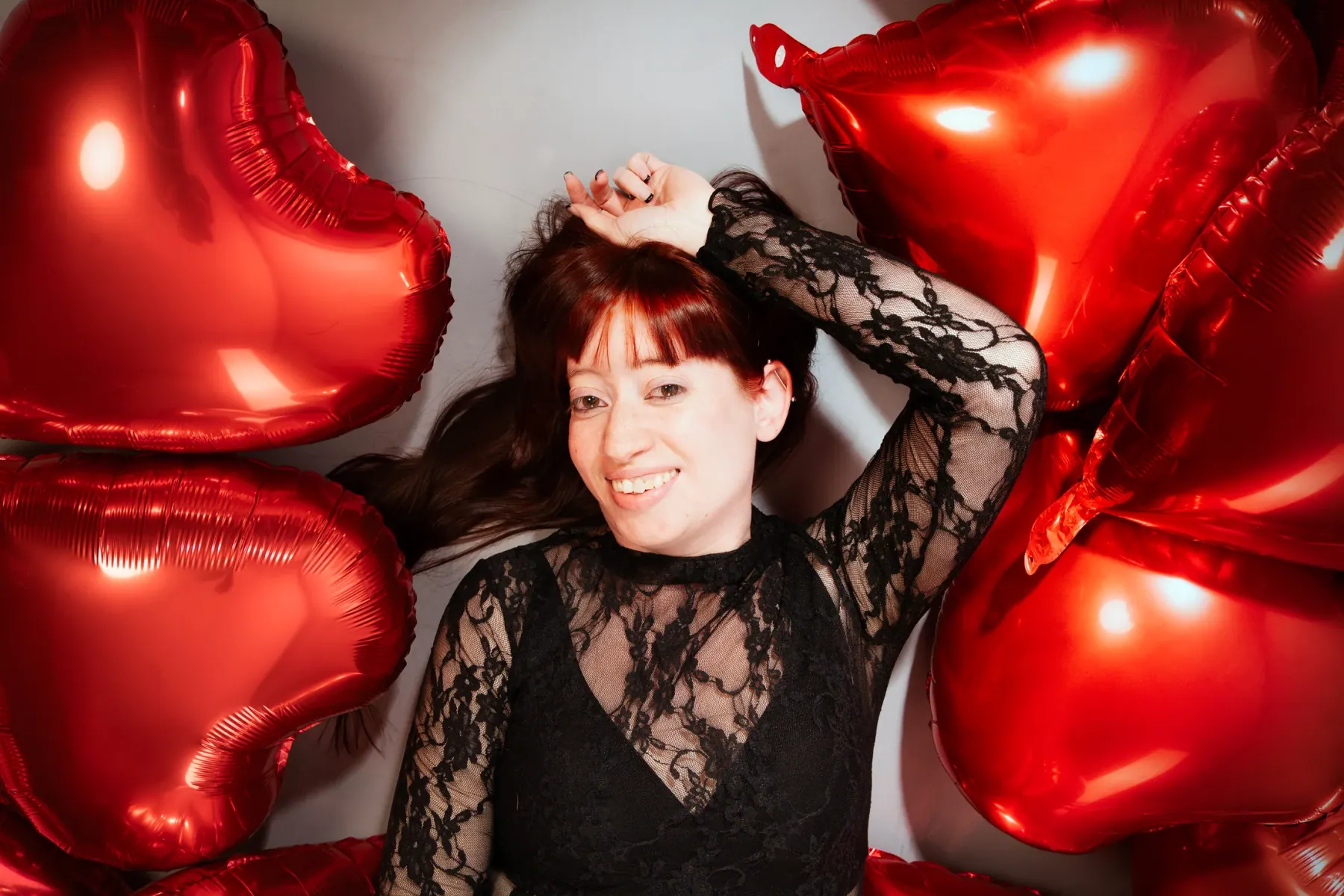 Boudoir portrait in black lace framed by red heart balloons
