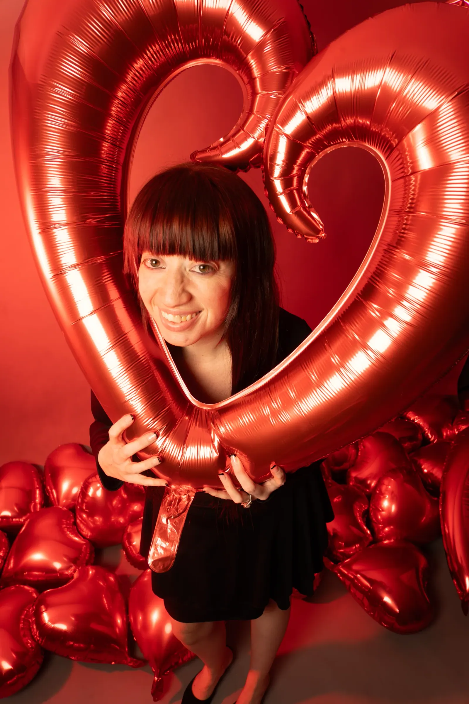 Playful black lace portrait with a sculptural heart balloon