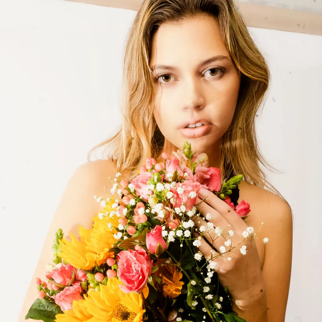 Soft fashion portrait with a fresh bouquet of flowers